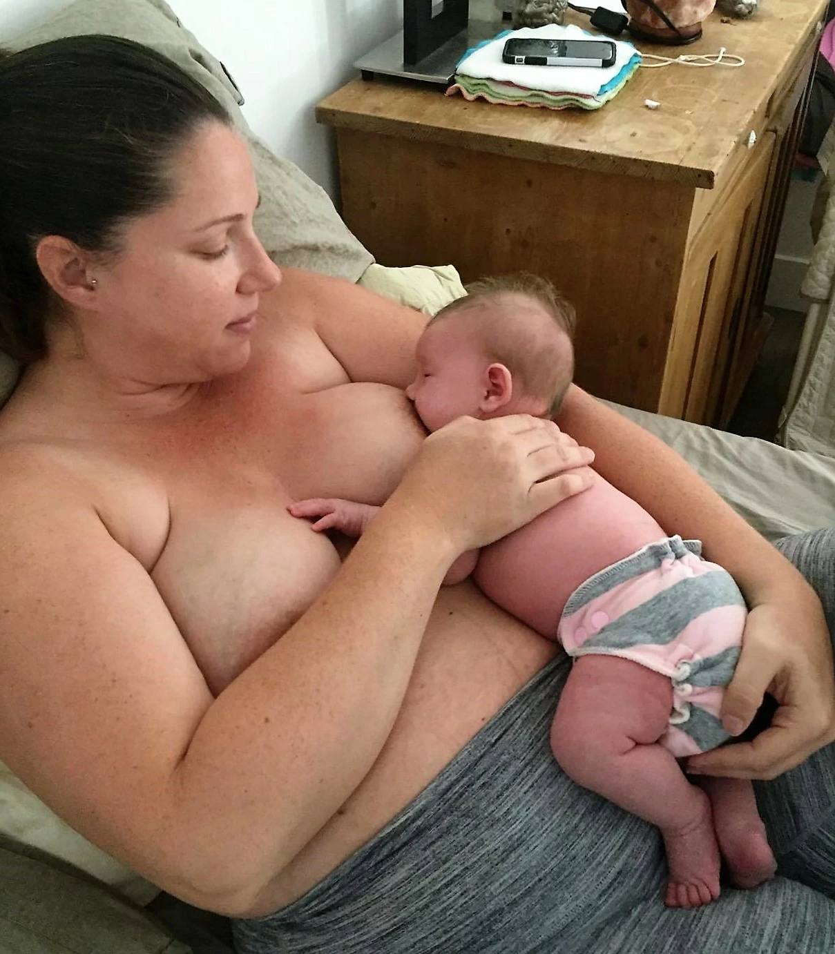 This 2 week old baby is enjoying milk in a laid back position. Mom is supporting baby's neck and back. Do not replicate without permission. 